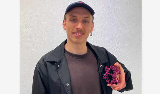 Portrait of Yannic Malte Müller with a 3D printed model of the host-guest system which was studied by him during his Bachelor thesis
