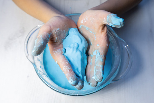 Hände mit blauer Masse Hände mit blauer Masse