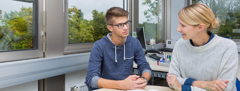 Two persons sitting at a desk